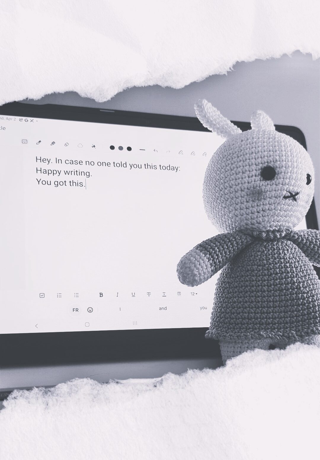 Black and white image of a crochet bunny next to a screen with message to writers typed on it: hey. In case no one told you this today: happy writing, you got this.